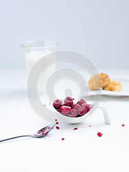 Delicious healthy breakfast with coconut cookies, rasberries and milk in glass as a background.