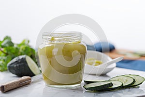 A delicious healthy breakfast with homemade cucumber jam and its ingredients in a glass jar