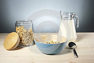 Delicious and healthy cereal in bowl with milk on table