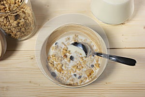 Delicious and healthy cereal in bowl with milk on table