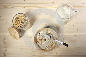 Delicious and healthy cereal in bowl with milk on table