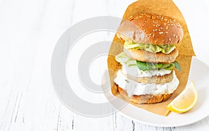 Delicious healthy crispy fish burger with greek yogurt sauce with lettuce and cucumber