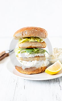 Delicious healthy crispy fish burger with greek yogurt sauce with lettuce and cucumber