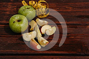 Delicious and healthy food for healthy and active people. Two whole green apples and one red Apple cut into pieces are lying on