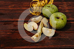 Delicious and healthy food for healthy and active people. Two whole green apples and one red Apple cut into pieces are lying on