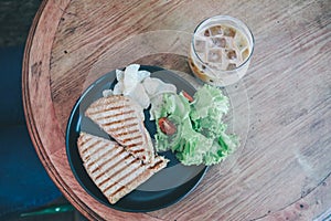 Delicious Healthy Grill sandwich ham cheese and salad  lettuce, ham, cheese, tomato and potato chipwith a cup of coffee.