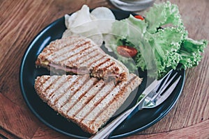 Delicious Healthy Grill sandwich ham cheese and salad  lettuce, ham, cheese, tomato and potato chipwith a cup of coffee.