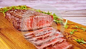 Delicious and healthy grilled medium rare beef steak on wooden board