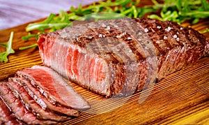 Delicious and healthy grilled medium rare beef steak on wooden board