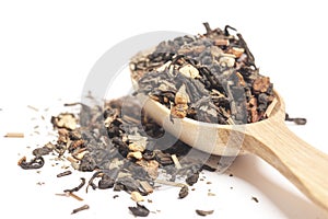 Delicious and healthy herbal green tropical tea with dried fruits in a wooden spoon isolated on white background.