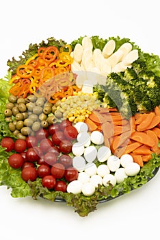 Delicious and healthy lettuce salad with various vegetables and quail egg isolated on white background in closeup top view