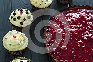 Delicious Healthy Raw Raspberry Tart with Valentines Day Red Velvet Cupcakes on Dark Wooden Background