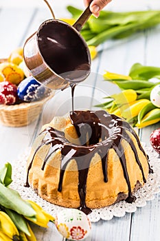 Delicious holiday slovak and czech cake babovka with chocolate glaze. Pouring chocolate topping. Easter decorations - spring