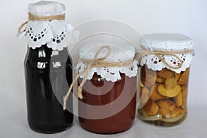 Delicious home made fruit preserves, marmalade, jam, marinated mushrooms in glass jars isolated