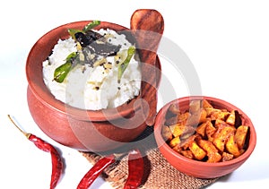 Delicious home made indian curd rice in a clay pot with fried potato