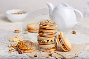 Delicious homemade alfajores cookies with milk caramel cream filling, decorated with pistachio nuts