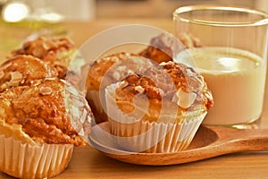 Delicious homemade almond muffins and a glass of milk on wooden