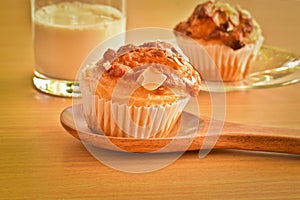 Delicious homemade almond muffins and a glass of milk on wooden