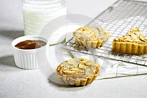 delicious homemade almond pies or tartlet with apricot jam and milk bottle.