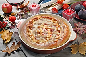 Delicious homemade apple pie and autumn decor on wooden table. Thanksgiving Day celebration