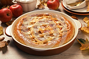 Delicious homemade apple pie and autumn leaves on wooden table. Thanksgiving Day celebration