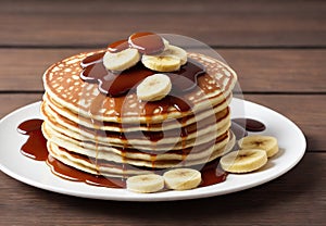 Delicious homemade banana pancakes with caramel on wooden table