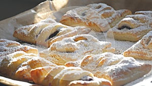 Delicious homemade cakes. Puff pastry with cherries, generously sprinkled with icing sugar on top. Delicious fresh buns