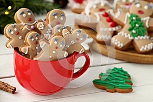 Delicious homemade Christmas cookies in cup on white wooden table. Space for text