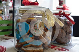 Delicious homemade colourful christmas cookies in a christmas plate and a jar and candle in the back