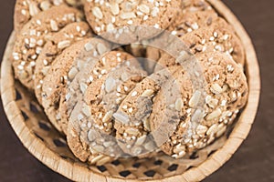 A delicious homemade cookie with cereals and seeds lies in a wicker basket