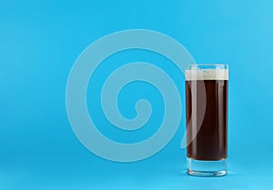 Delicious homemade kvass in glass on light blue background. Space for text