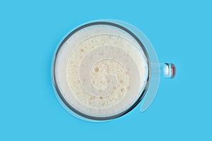 Delicious homemade kvass in glass mug on blue background, top view