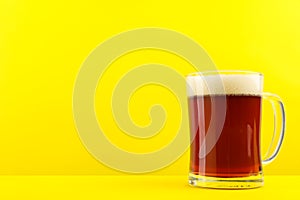 Delicious homemade kvass in glass mug on yellow background. Space for text
