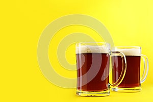 Delicious homemade kvass in glass mugs on yellow background. Space for text