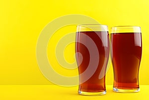 Delicious homemade kvass in glasses on yellow background.