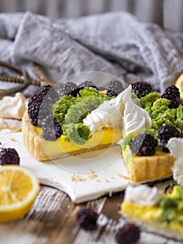 Delicious homemade lemon tart. Pie on rustic white table. Tart with blackberry and meringue