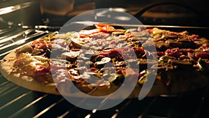 Delicious homemade pizza baking in the oven. Pepperoni, jalapeno and mushroom pizza, italian food on metal grate. Food background