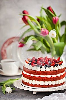 Delicious homemade red velvet cake decorated with cream and fresh berries