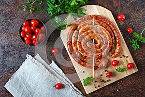 Delicious homemade sausages, baked  rings on skewers, with cherry tomatoes. Oktoberfest snack. Summer picnic dish