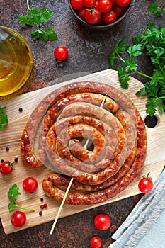 Delicious homemade sausages, baked  rings on skewers, with cherry tomatoes. Oktoberfest snack. Summer picnic dish