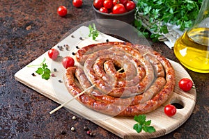 Delicious homemade sausages, baked  rings on skewers, with cherry tomatoes. Oktoberfest snack. Summer picnic dish