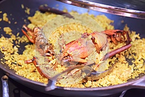 Delicious Homemade Seafood Lobster Paella studded with succulent lobsters, a renown Spanish dish with its characteristic golden