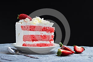 Delicious homemade strawberry cake and fresh milk cream in white dish on gray stone table rustic style. Side view with copy space