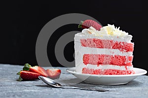 Delicious homemade strawberry cake and fresh milk cream in white dish on gray stone table rustic style. Side view with copy space