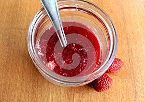 Delicious homemade strawberry jam in a glass jar and fresh strawberries
