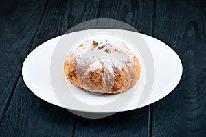 Delicious homemade sweet eclair on dark wooden background.