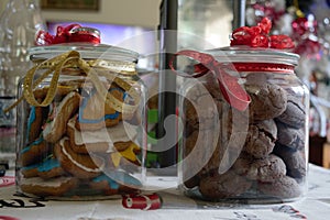 Delicious homemade tasty christmas cookies and in a beautiful decorated jar and a christmas tree and a candle in the back