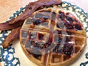 Delicious Homemade Waffle with Mixed Berry Syrup and Bacon for Breakfast