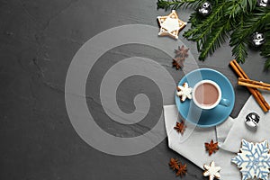 Delicious hot chocolate, cookies and Christmas decor on black table, flat lay. Space for text