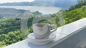 Delicious hot coffee on border of terrace with mountain view in Kintamani Bali. Perfect morning with hot drink